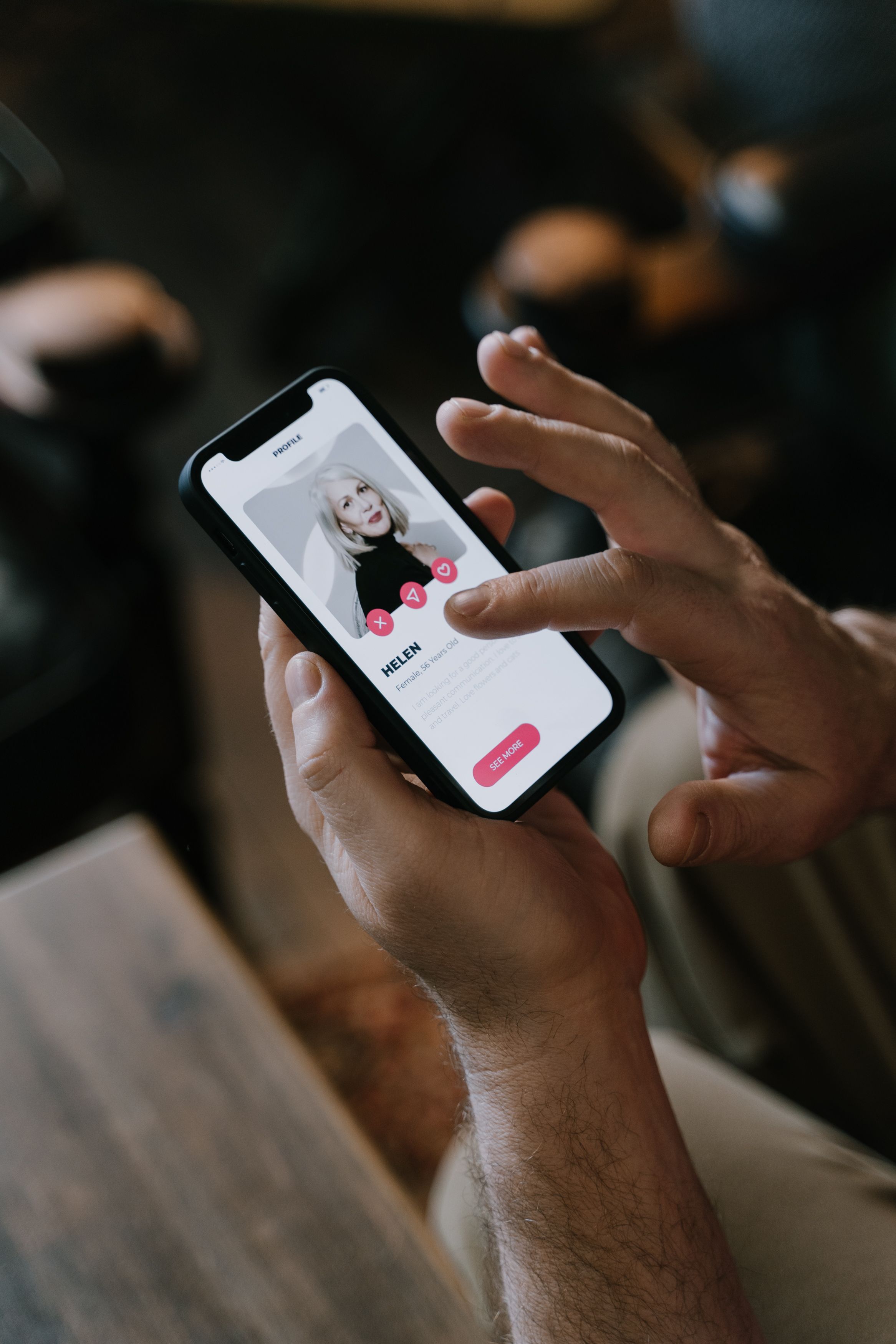Close-up of hands using a dating app on a smartphone indoors