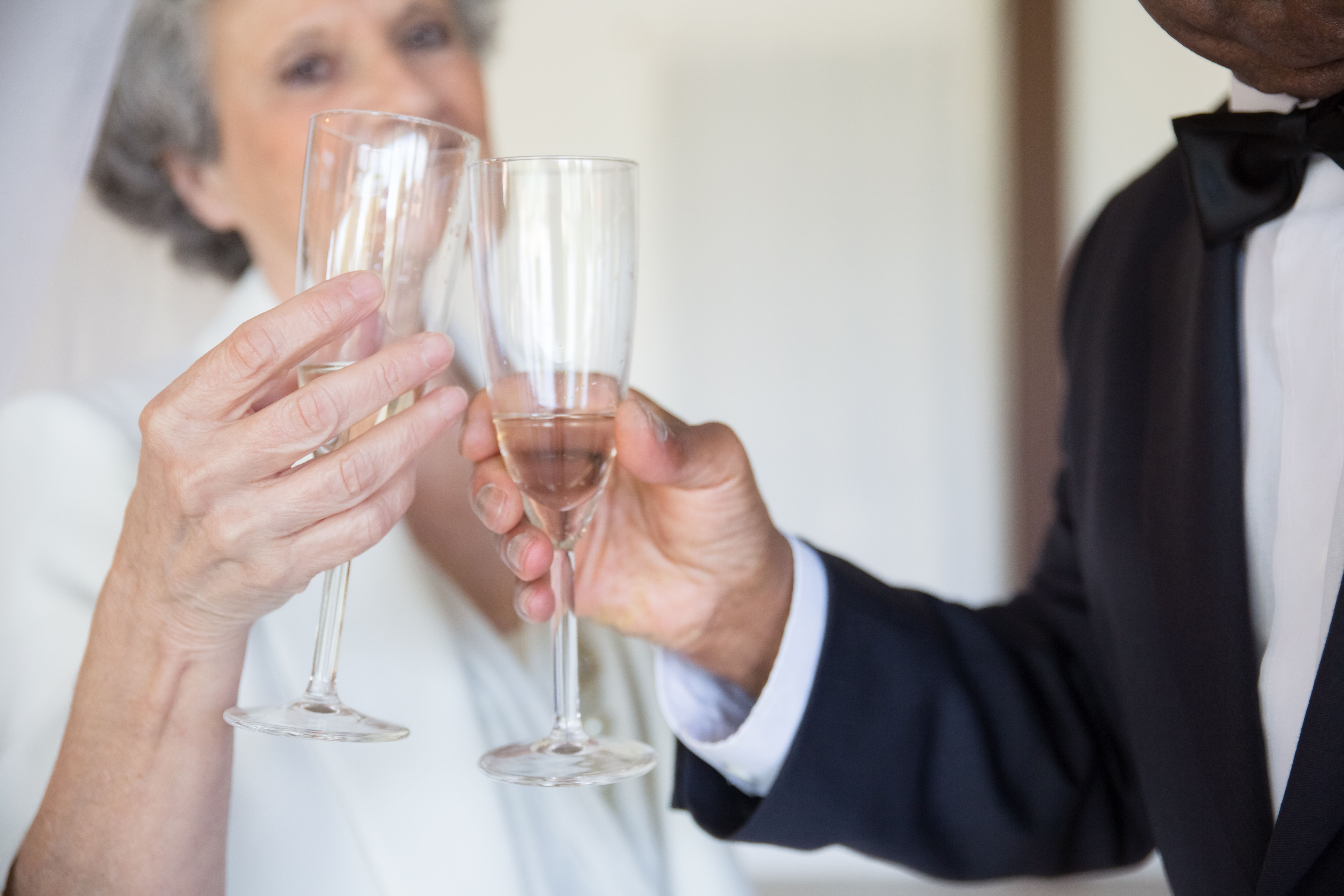 Well-dressed couple toasting with champagne glasses, celebrating together