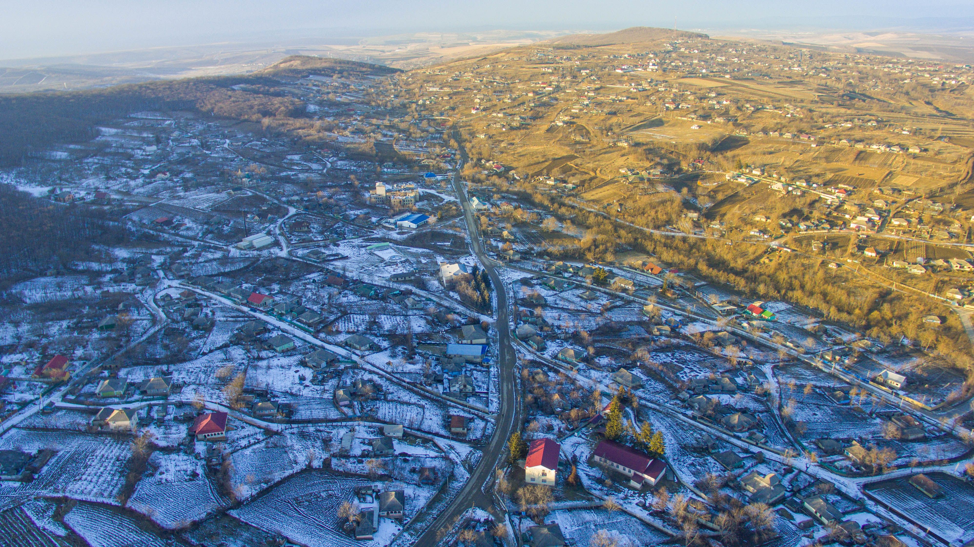 Aerial view of a town surrounded by snowy countryside, showing rural community life in winter