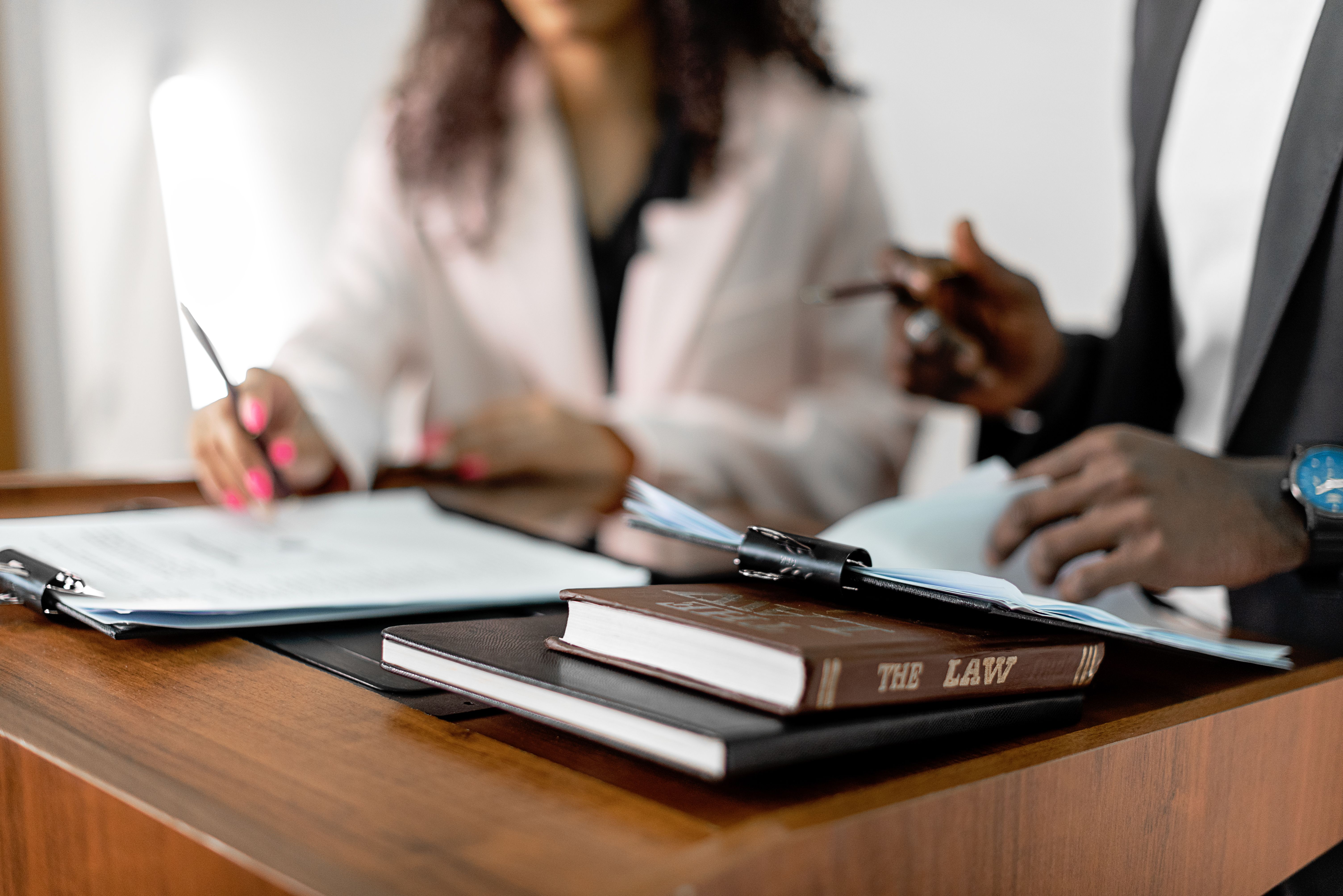 Two lawyers reviewing documents beside law books at a desk