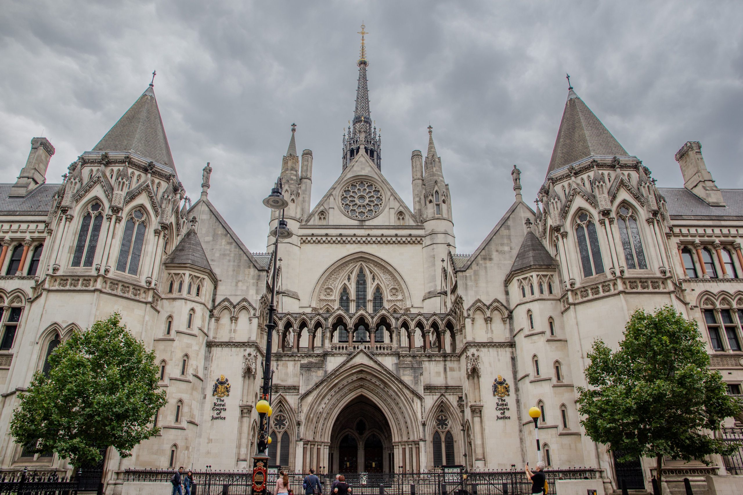 Exterior of the Royal Courts of Justice in London, a key institution in the UK legal system, under cloudy skies